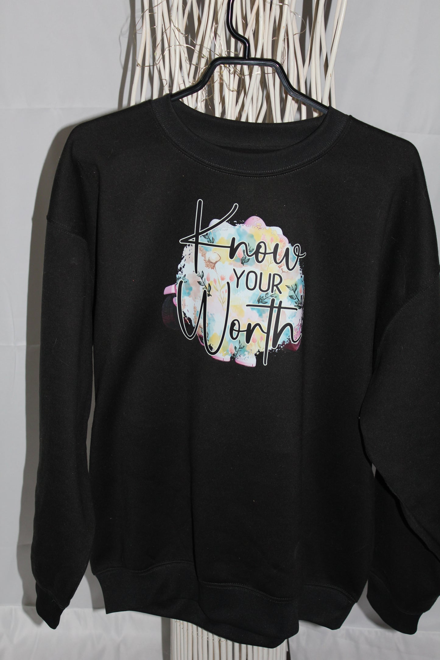 Crewneck femme noir col rond avec message “Know Your Worth” et fond floral pastel